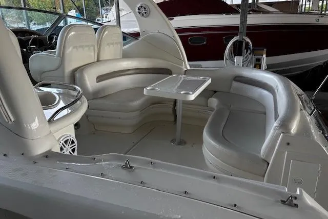 Slide: The Image of 2005 Sea Ray 340 Sundancer interior with white seating and table in a marina. - 4