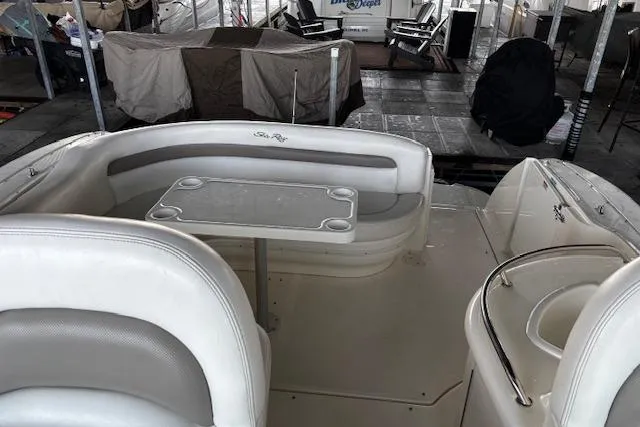 Slide: The Image of 2005 Sea Ray 340 Sundancer boat interior with seating and table in a marina setting. - 8