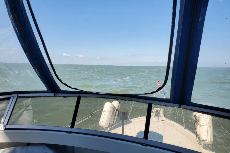 Slide: The Image of View from 1994 Carver 390 Cockpit Motor Yacht navigating open waters under clear blue sky. - 12