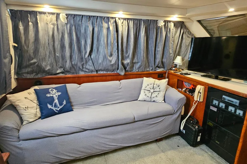 Slide: The Image of Interior of 1994 Carver 390 Cockpit Motor Yacht with sofa, nautical pillows, and TV. - 18