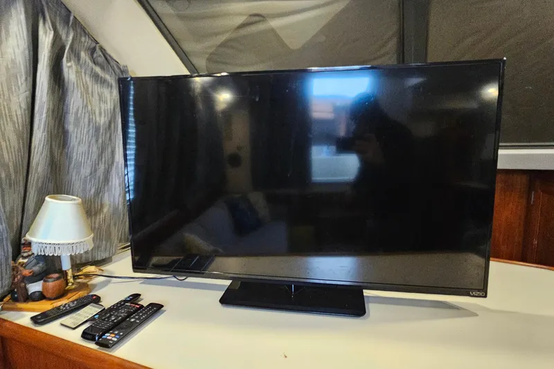 Slide: The Image of Flat-screen TV with remotes on a Carver 390 Cockpit Motor Yacht, 1994 model. - 19