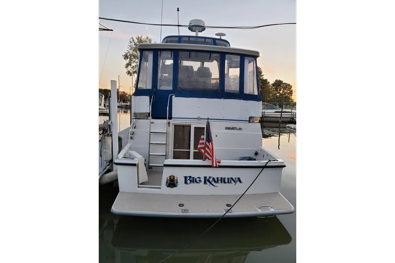 Slide: The Image of 1994 Carver 390 Cockpit Motor Yacht docked, featuring "Big Kahuna" name and American flag. - 3