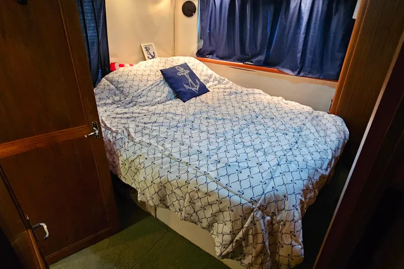 Slide: The Image of Cozy bedroom in 1994 Carver 390 Cockpit Motor Yacht with nautical-themed bedding. - 31