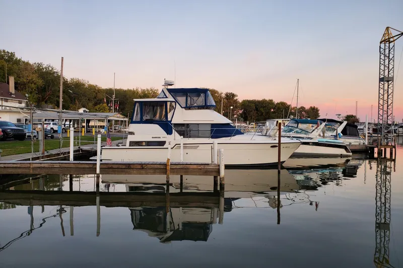 Slide: The Image of 1994 Carver 390 Cockpit Motor Yacht docked at sunset in a serene marina. - 4