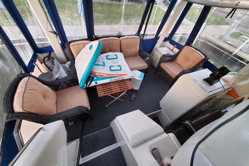 Slide: The Image of 1994 Carver 390 Cockpit Motor Yacht interior with wicker seating and paddleboard. - 7