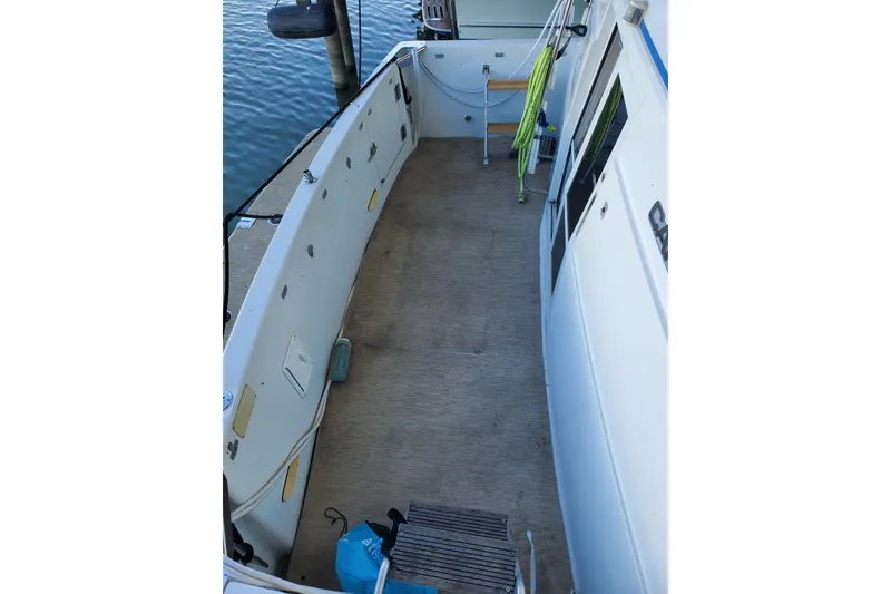 Slide: The Image of 1994 Carver 390 Cockpit Motor Yacht deck with hose and dock view. - 13