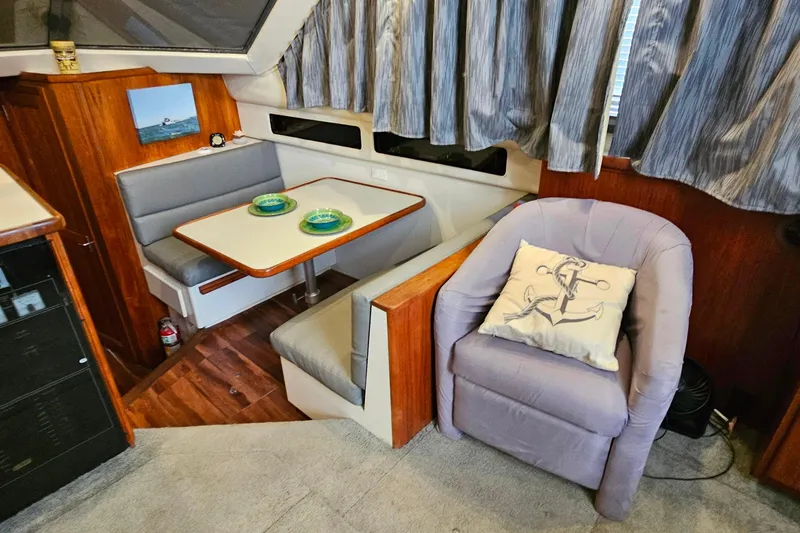 Slide: The Image of 1994 Carver 390 Cockpit Motor Yacht interior with dining area and cozy seating. - 16