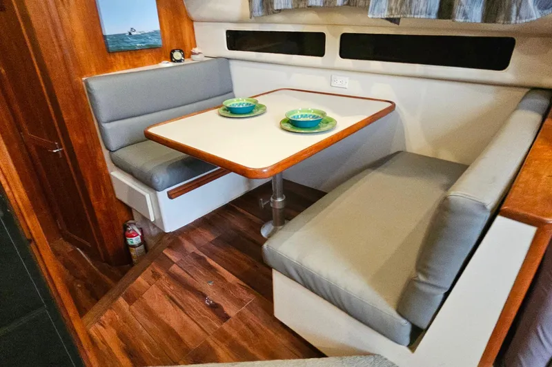 Slide: The Image of Interior of 1994 Carver 390 Cockpit Motor Yacht with cozy dining area and wooden accents. - 21