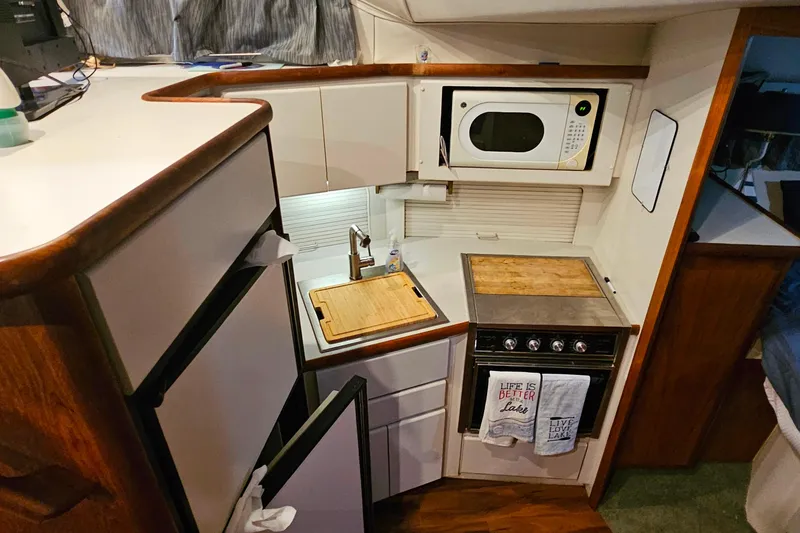 Slide: The Image of Compact kitchen in a 1994 Carver 390 Cockpit Motor Yacht with stove, microwave, and fridge. - 22