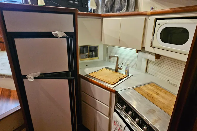 Slide: The Image of 1994 Carver 390 Cockpit Motor Yacht kitchen with fridge, stove, and microwave. - 23