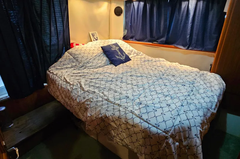 Slide: The Image of Cozy bedroom in 1994 Carver 390 Cockpit Motor Yacht with nautical-themed bedding. - 32