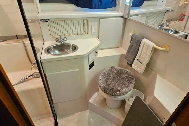 Slide: The Image of 1994 Carver 390 Cockpit Motor Yacht bathroom with sink, toilet, and towels. - 34