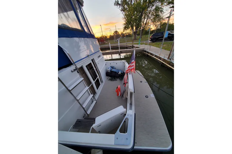 Slide: The Image of 1994 Carver 390 Cockpit Motor Yacht docked at sunset with American flag. - 6