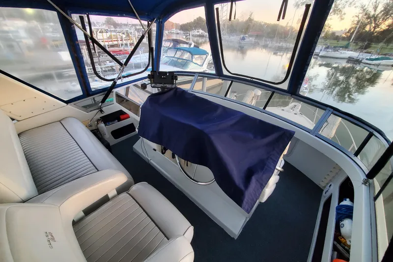 Slide: The Image of 1994 Carver 390 Cockpit Motor Yacht interior with helm, seating, and marina view. - 8