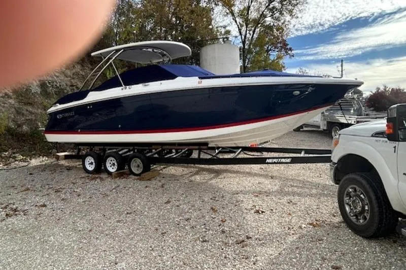 Slide: The Image of 2014 Cobalt 302 boat on trailer, parked outdoors with trees and sky in background. - 0