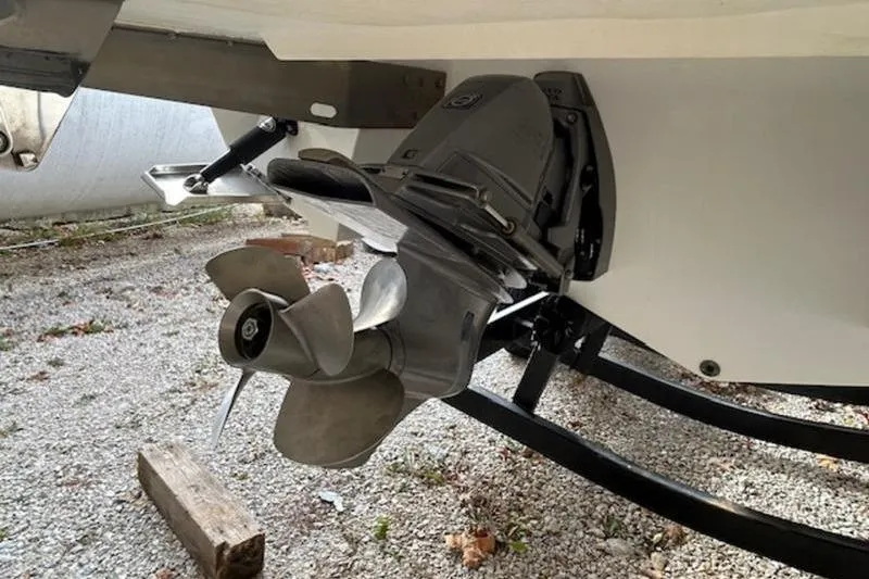 Slide: The Image of 2014 Cobalt 302 boat propeller and stern drive on gravel surface. - 1