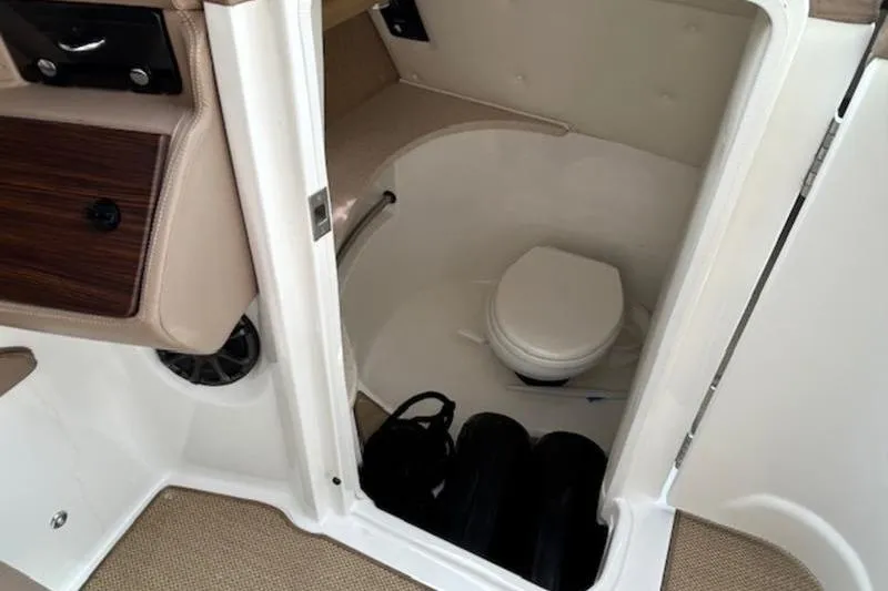 Slide: The Image of 2014 Cobalt 302 boat interior with compact marine toilet and storage area. - 10