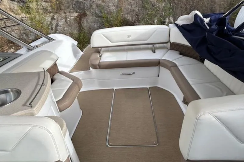 Slide: The Image of 2014 Cobalt 302 boat interior with white and beige seating and a small sink. - 12