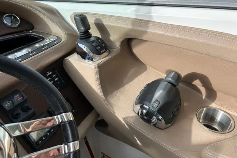 Slide: The Image of 2014 Cobalt 302 boat dashboard with controls and cup holder. - 19