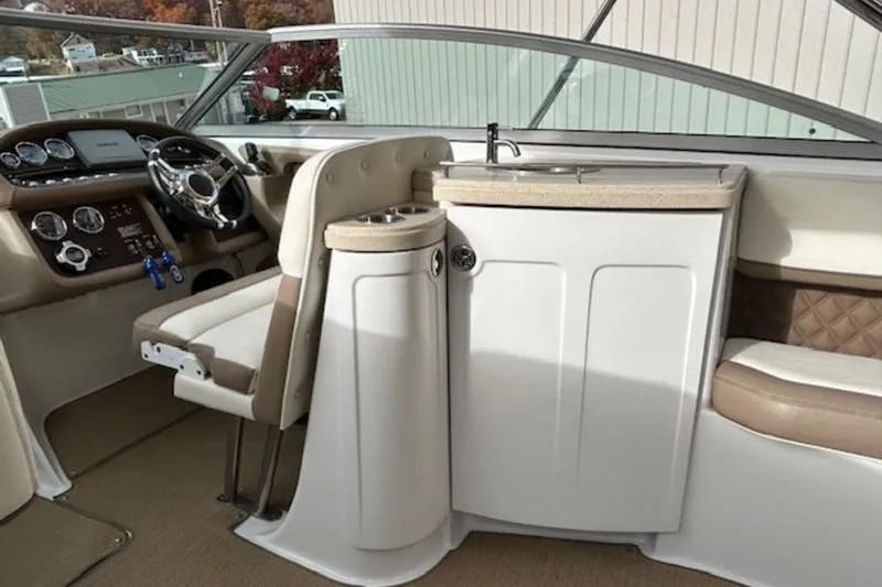 Slide: The Image of Interior of a 2014 Cobalt 302 boat featuring a steering console and sink area. - 6