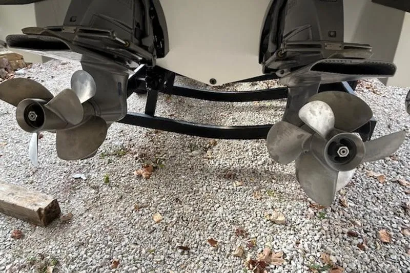 Slide: The Image of 2014 Cobalt 302 boat propellers on gravel surface, showcasing dual outboard motors. - 7