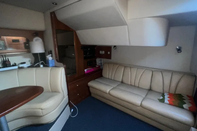 Slide: The Image of 2001 Cruisers Yachts 3572 Express interior with beige seating and wooden accents. - 12