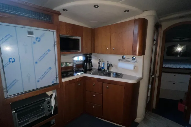 Slide: The Image of 2001 Cruisers Yachts 3572 Express interior kitchen with wood cabinets and modern appliances. - 14