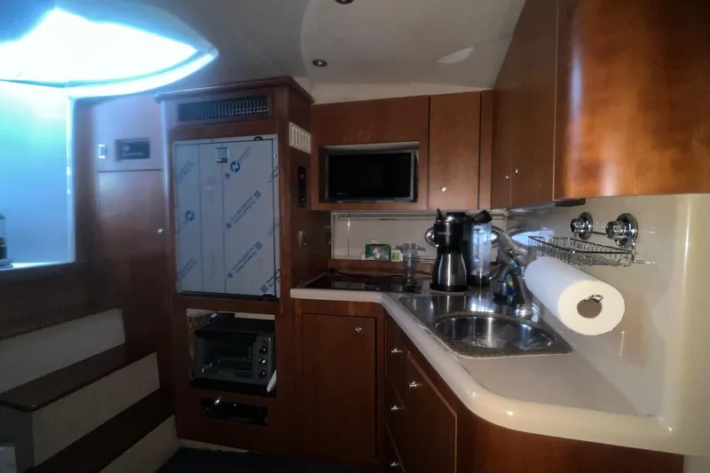 Slide: The Image of 2001 Cruisers Yachts 3572 Express kitchen interior with wooden cabinets and modern appliances. - 16