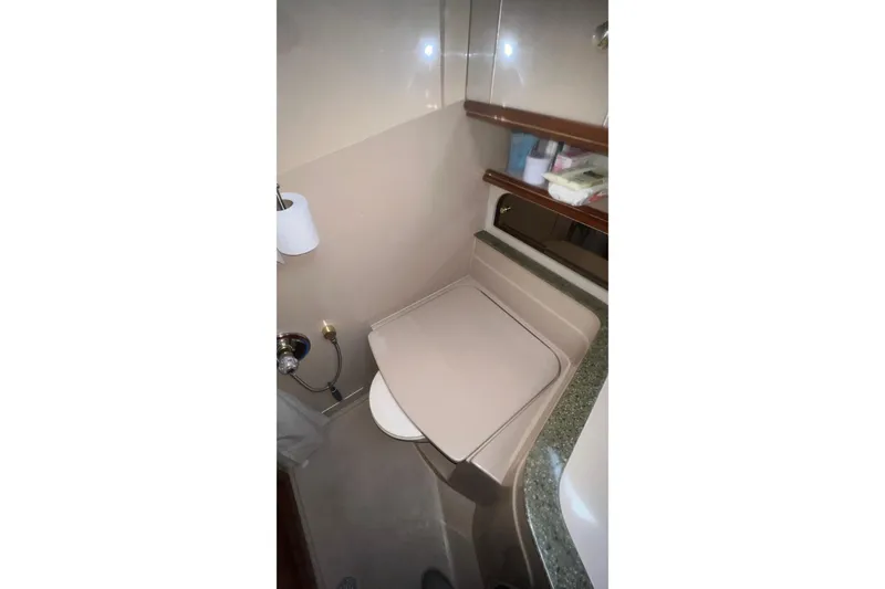 Slide: The Image of 2001 Cruisers Yachts 3572 Express bathroom with toilet and storage shelves. - 24