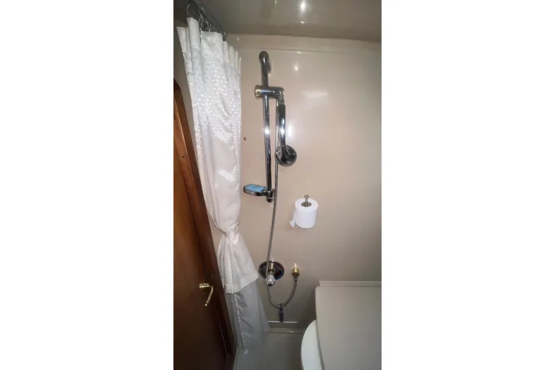 Slide: The Image of 2001 Cruisers Yachts 3572 Express bathroom with shower, curtain, and toilet paper holder. - 26