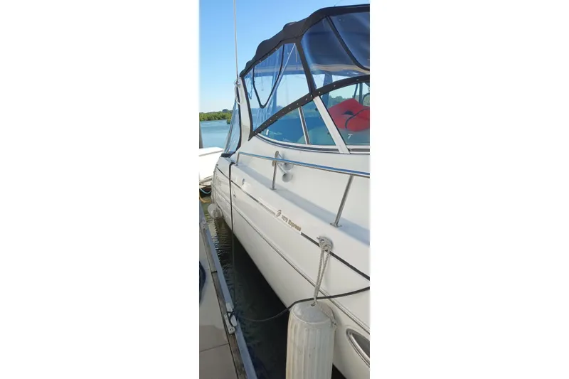 Slide: The Image of 2001 Cruisers Yachts 3572 Express docked, featuring sleek design and protective canopy. - 27