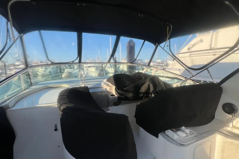 Slide: The Image of 2001 Cruisers Yachts 3572 Express cockpit with covered seats and marina view. - 5