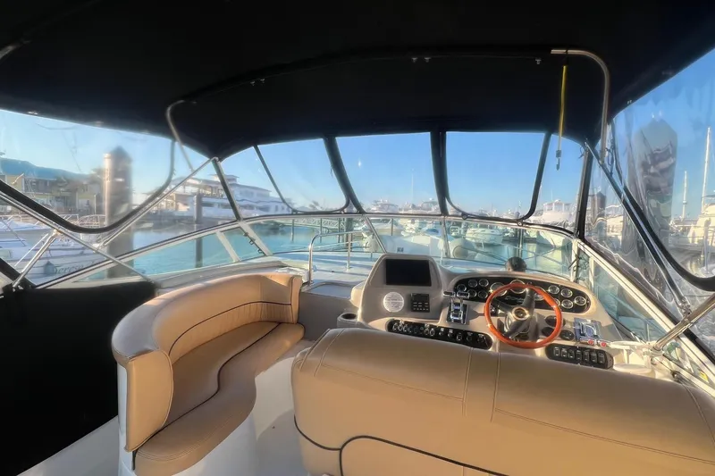 Slide: The Image of 2001 Cruisers Yachts 3572 Express cockpit with steering wheel and seating, docked at marina. - 7