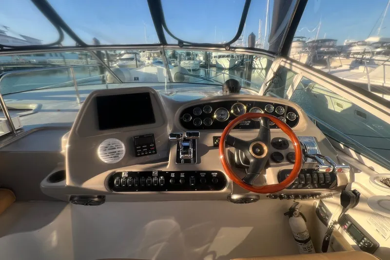 Slide: The Image of 2001 Cruisers Yachts 3572 Express helm with steering wheel and control panel. - 8