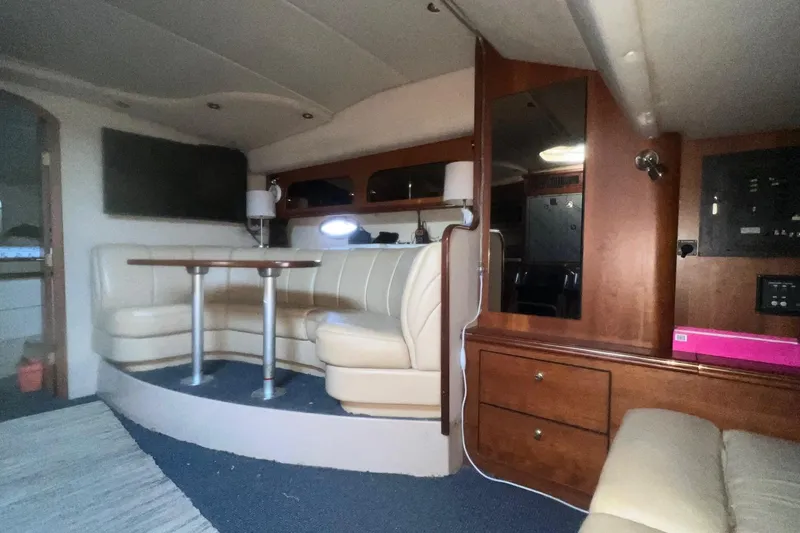 Slide: The Image of Interior of 2001 Cruisers Yachts 3572 Express with cozy seating and wooden cabinetry. - 11