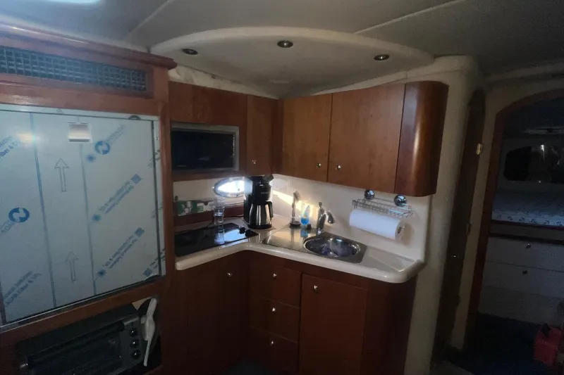 Slide: The Image of 2001 Cruisers Yachts 3572 Express interior kitchen with wooden cabinets and modern appliances. - 13