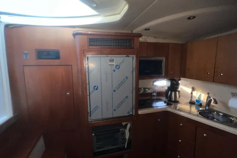 Slide: The Image of 2001 Cruisers Yachts 3572 Express interior kitchen with wooden cabinets and modern appliances. - 15