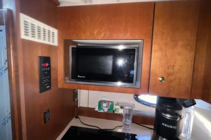 Slide: The Image of 2001 Cruisers Yachts 3572 Express kitchen with microwave and Keurig coffee maker. - 17