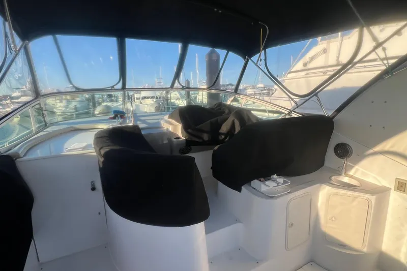 Slide: The Image of 2001 Cruisers Yachts 3572 Express cockpit with covered seats and marina view. - 4
