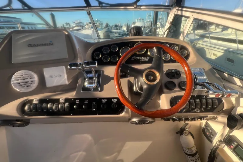 Slide: The Image of 2001 Cruisers Yachts 3572 Express helm with Garmin navigation and wooden steering wheel. - 9