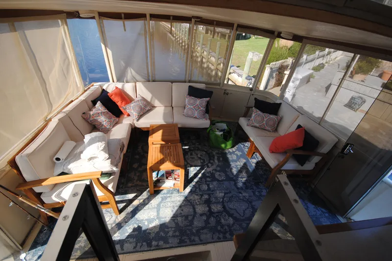 Slide: The Image of Cozy seating area on 1986 Viking 50 Motor Yacht with cushions and wooden table. - 16