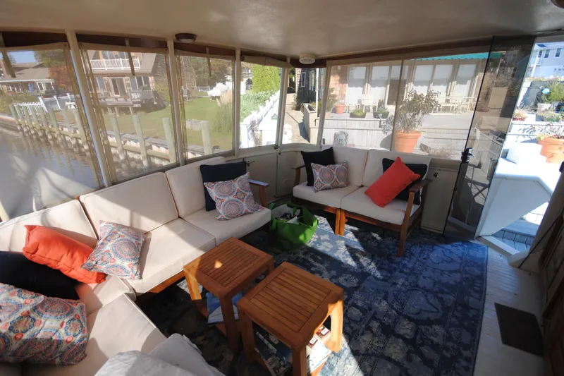 Slide: The Image of Enclosed deck of 1986 Viking 50 Motor Yacht with cozy seating and decorative pillows. - 17