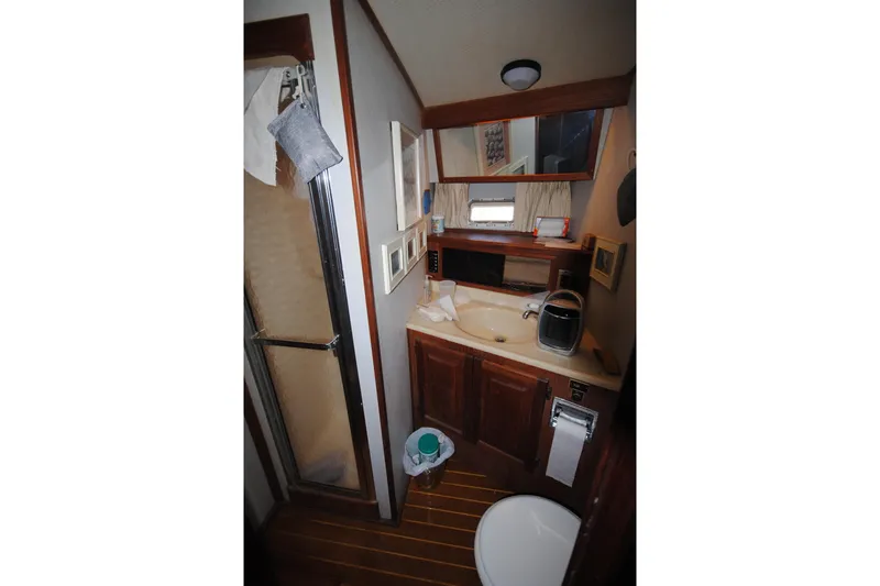 Slide: The Image of Bathroom interior of 1986 Viking 50 Motor Yacht with shower and wooden cabinetry. - 23