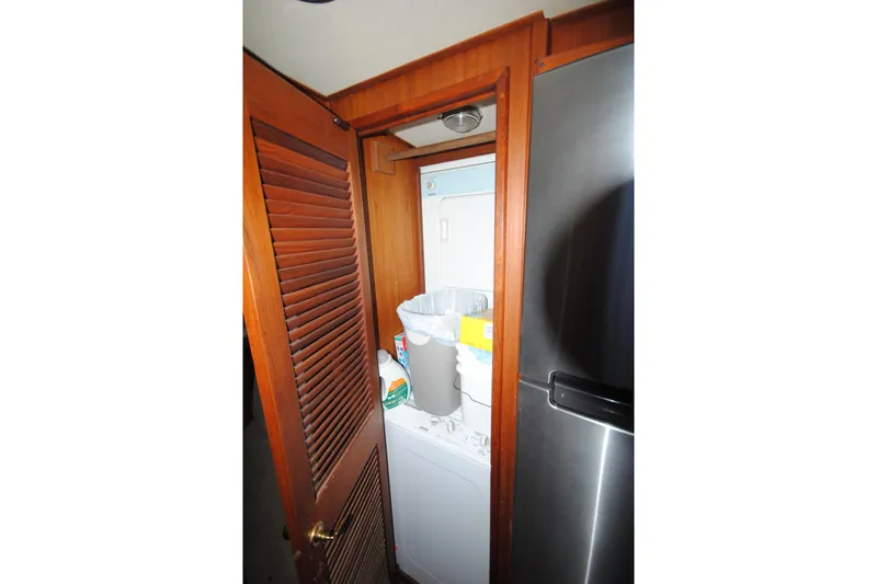 Slide: The Image of Laundry area inside 1986 Viking 50 Motor Yacht with wooden door and appliances. - 25