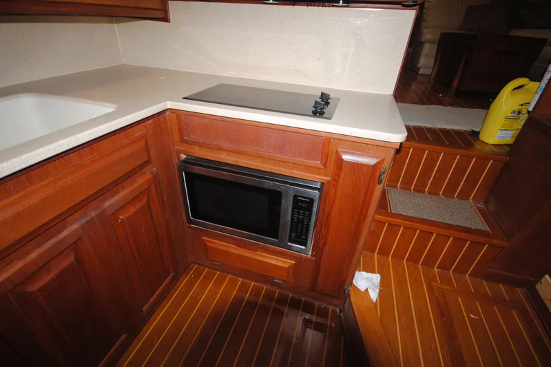 Slide: The Image of 1986 Viking 50 Motor Yacht kitchen with microwave, stove, and wooden cabinetry. - 29