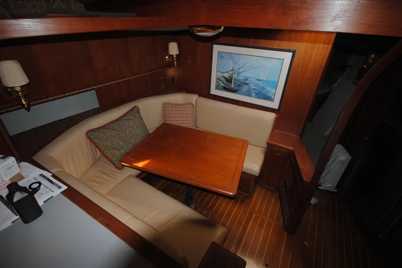 Slide: The Image of Cozy dining area in 1986 Viking 50 Motor Yacht with wood table and nautical artwork. - 30