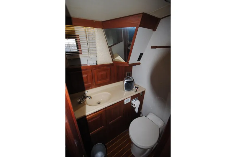 Slide: The Image of Bathroom interior of 1986 Viking 50 Motor Yacht with sink, mirror, and toilet. - 38