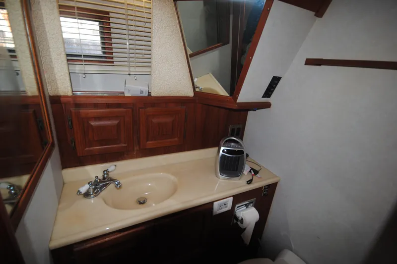 Slide: The Image of Bathroom interior of 1986 Viking 50 Motor Yacht with wooden cabinets and sink. - 39