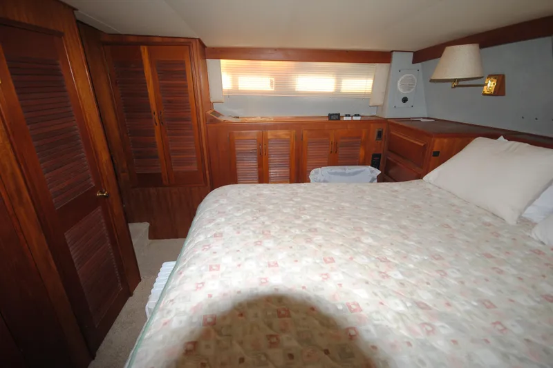 Slide: The Image of Cozy bedroom interior of 1986 Viking 50 Motor Yacht with wood paneling and soft lighting. - 44