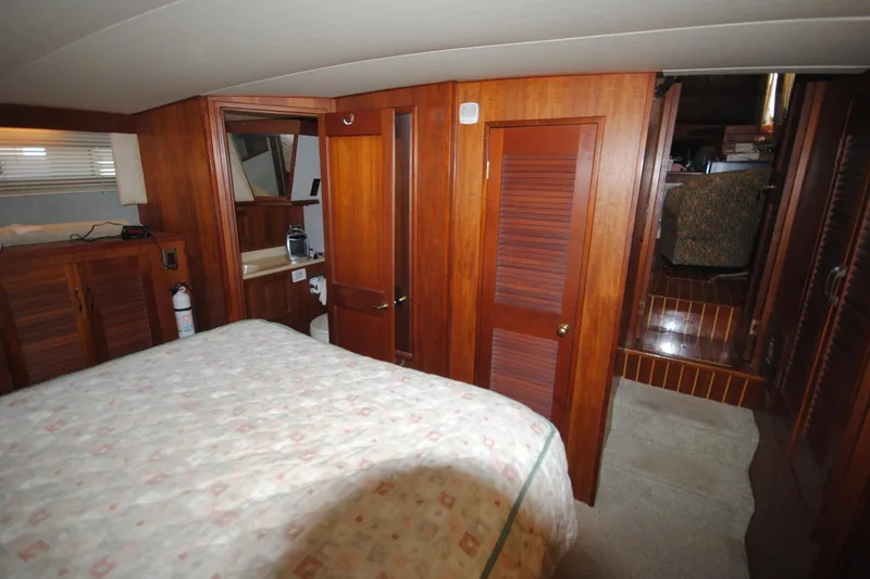 Slide: The Image of 1986 Viking 50 Motor Yacht interior with wood paneling and cozy bedroom. - 46